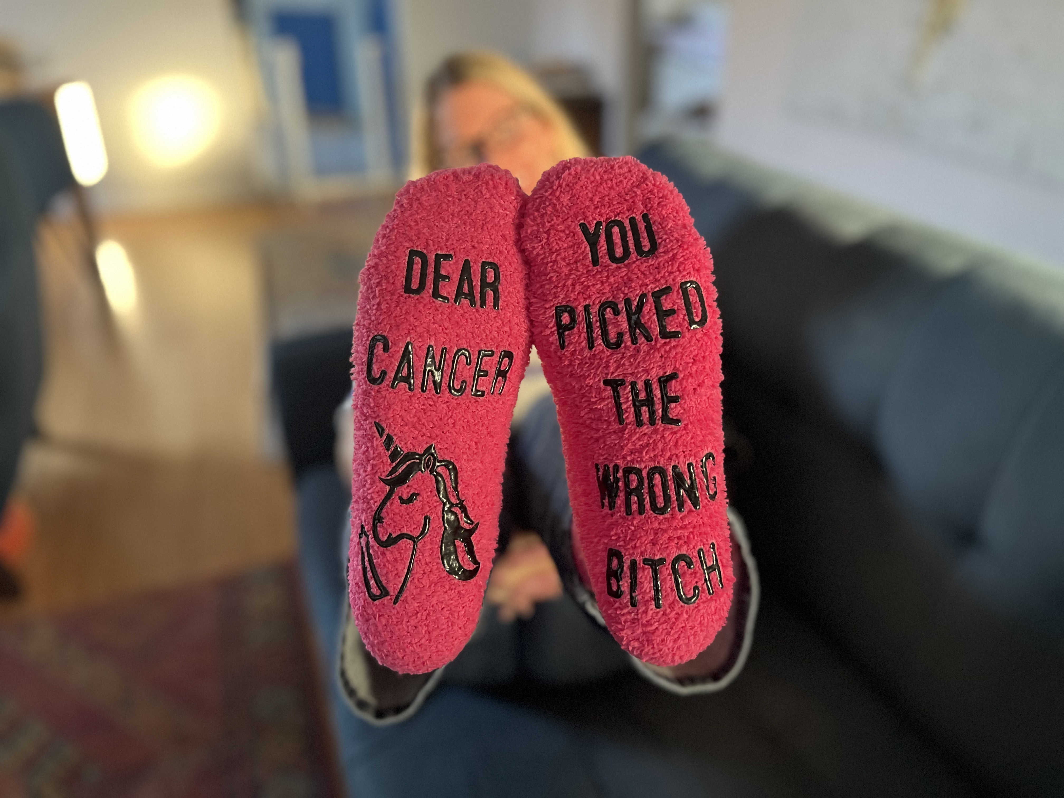 Pink socks featuring the words "Dear Cancer You picked the wrong *itch
